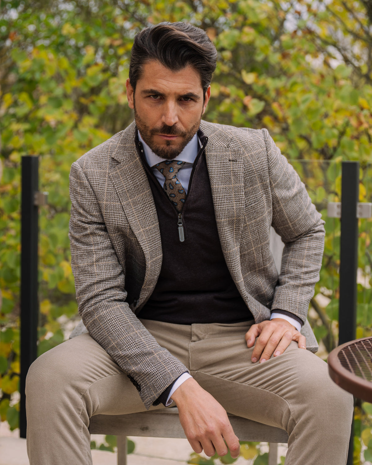 Due uomini al tavolino di un caffè con giacca e maglia della collezione autunno inverno